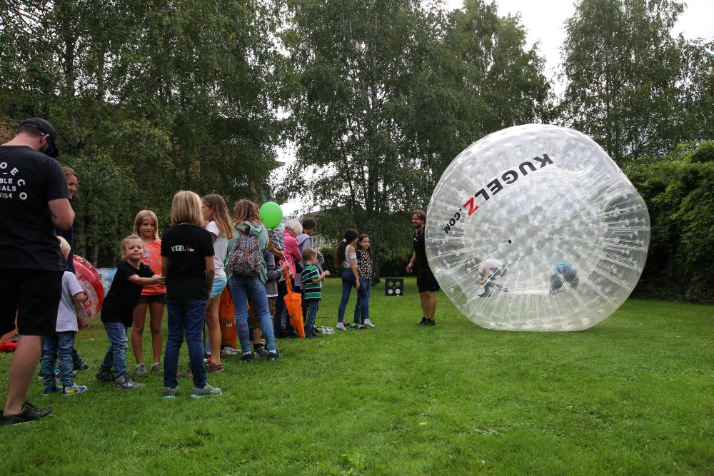Riesige XXL Riesen Zorb Kugel, durchsichtig - eine lange Schlange an Menschen die ansteht