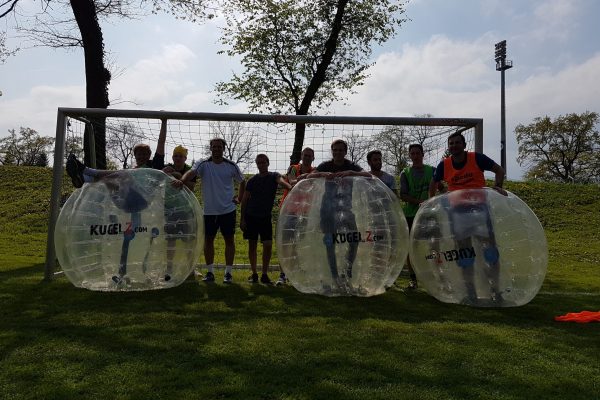Bubble Soccer Polterabend im freien. Männer stehen in einer Reihe.