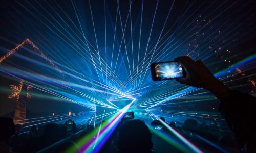 Lasershow von Ländle Event. Jemand fotografiert die Lasershow.