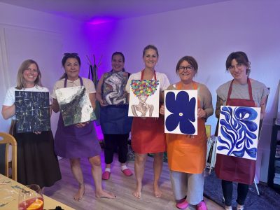Paint and Drink Event von Ländle Event. Abschlussfoto Teilnehmer zeigen ihre gemalten Bilder.