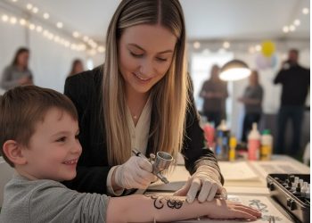 Eine Airbrush Artistin die einem Kind ein ein airbrush Tatoo macht